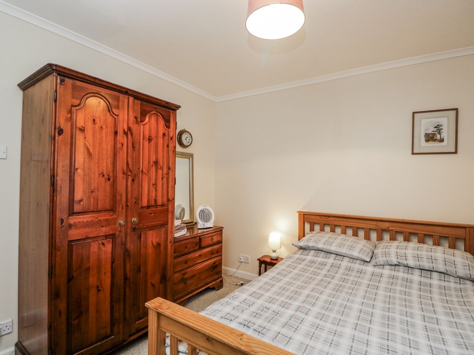 A bedroom with a bed, wardrobe, and dresser at Maindy Lodge