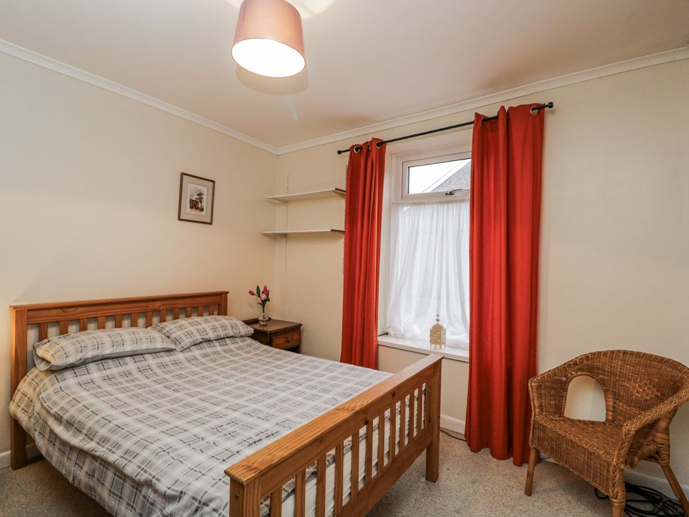 A bedroom with a bed and chair at Maindy Lodge