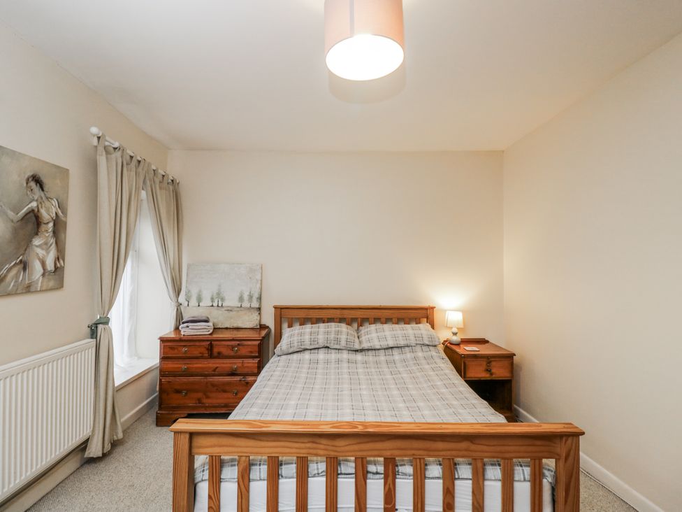 A bedroom with a bed and bedside table at Maindy Lodge
