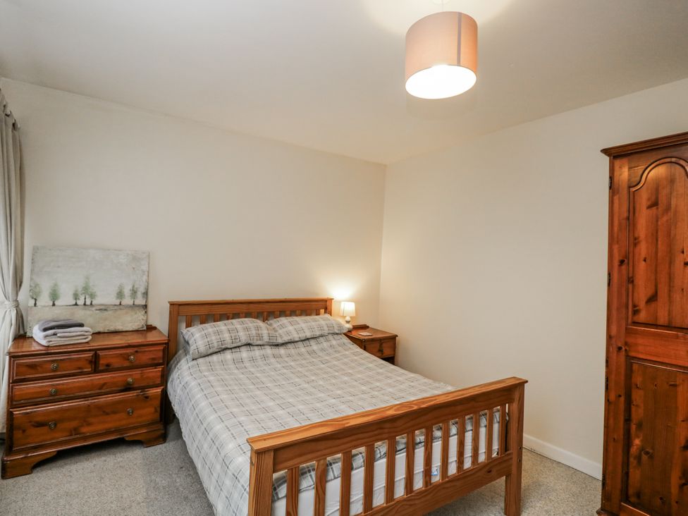 A bedroom with a bed and dresser at Maindy Lodge