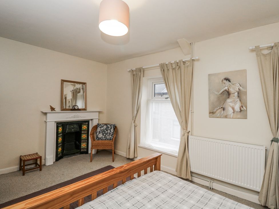 A bedroom with a bed and armchair at Maindy Lodge