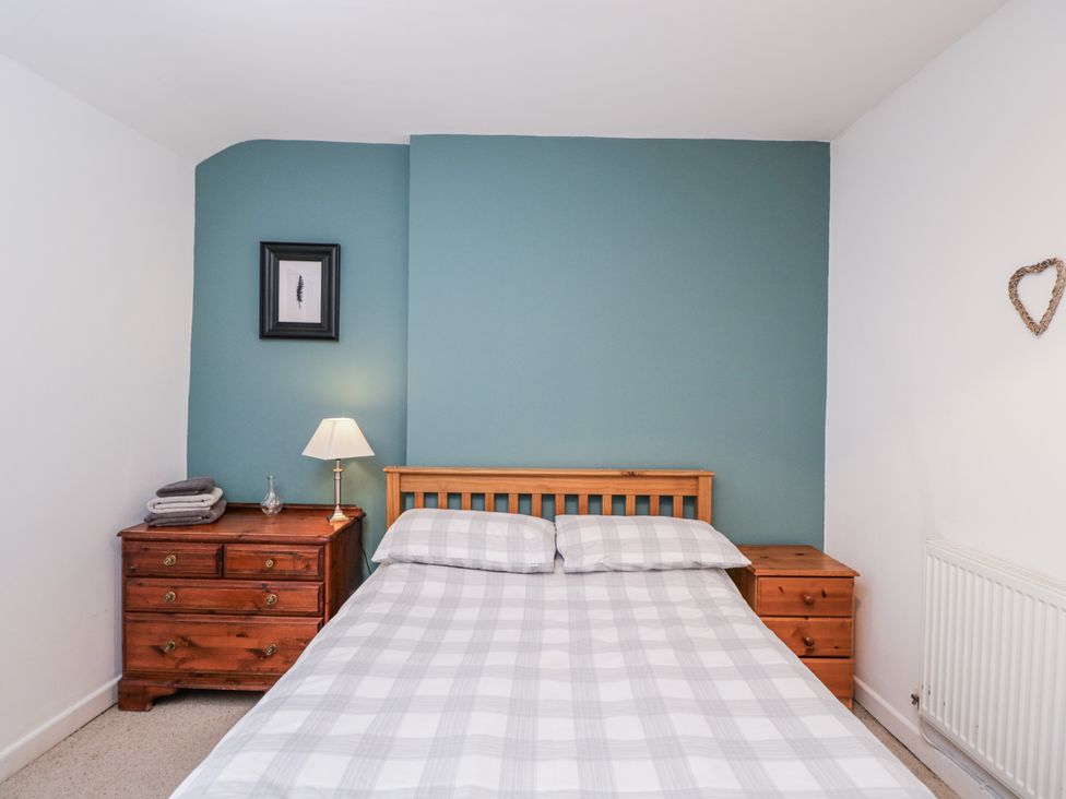 A bedroom with a bed and nightstand at Maindy Lodge