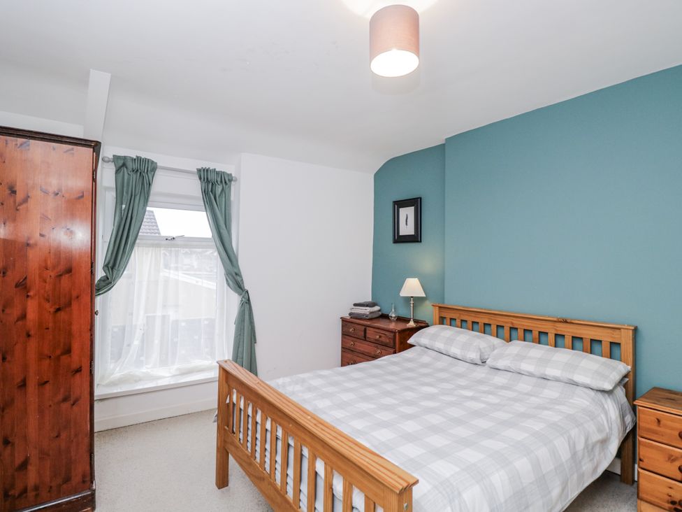 A bedroom with a bed and wardrobe at Maindy Lodge