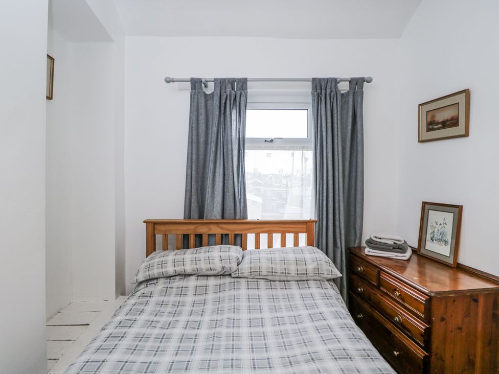A bedroom with a bed and dresser at Maindy Lodge