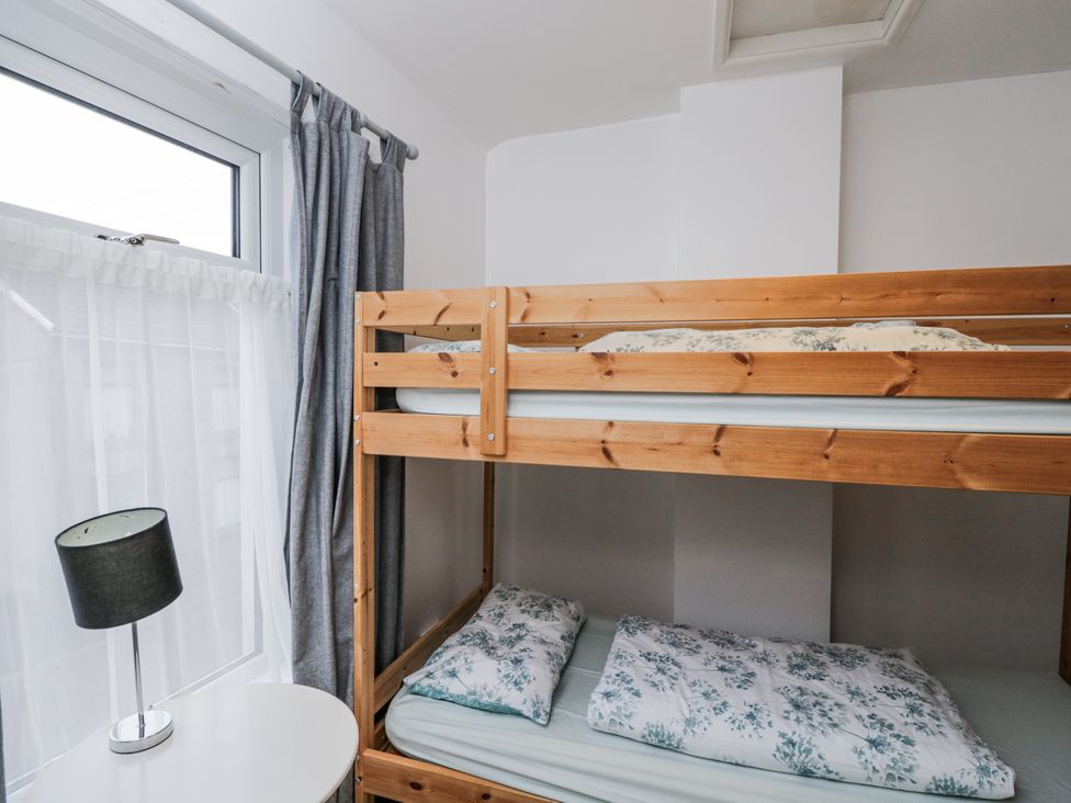 A bedroom with a bunk bed and a lamp at Maindy Lodge 
