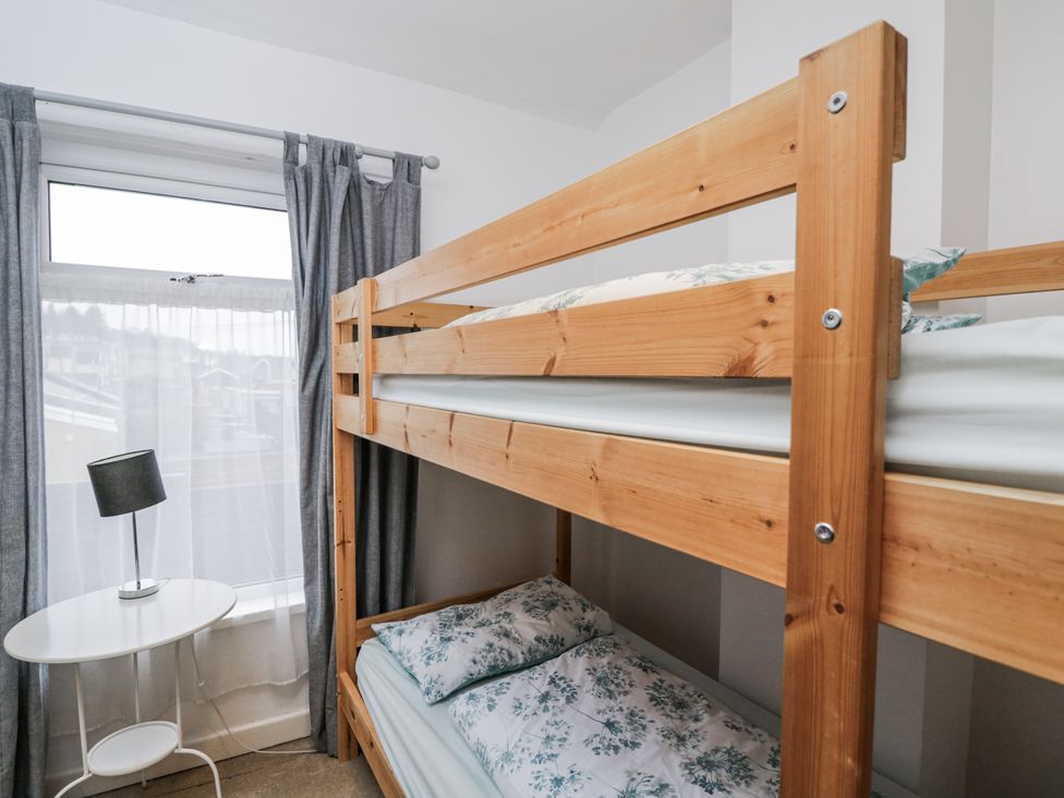 A bedroom with a bunk bed and a lamp at Maindy Lodge