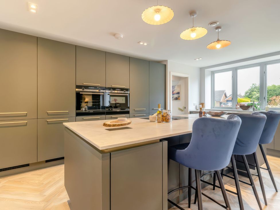 A kitchen with a central island and bar stools at The Old Butchers Arms in Sheffield