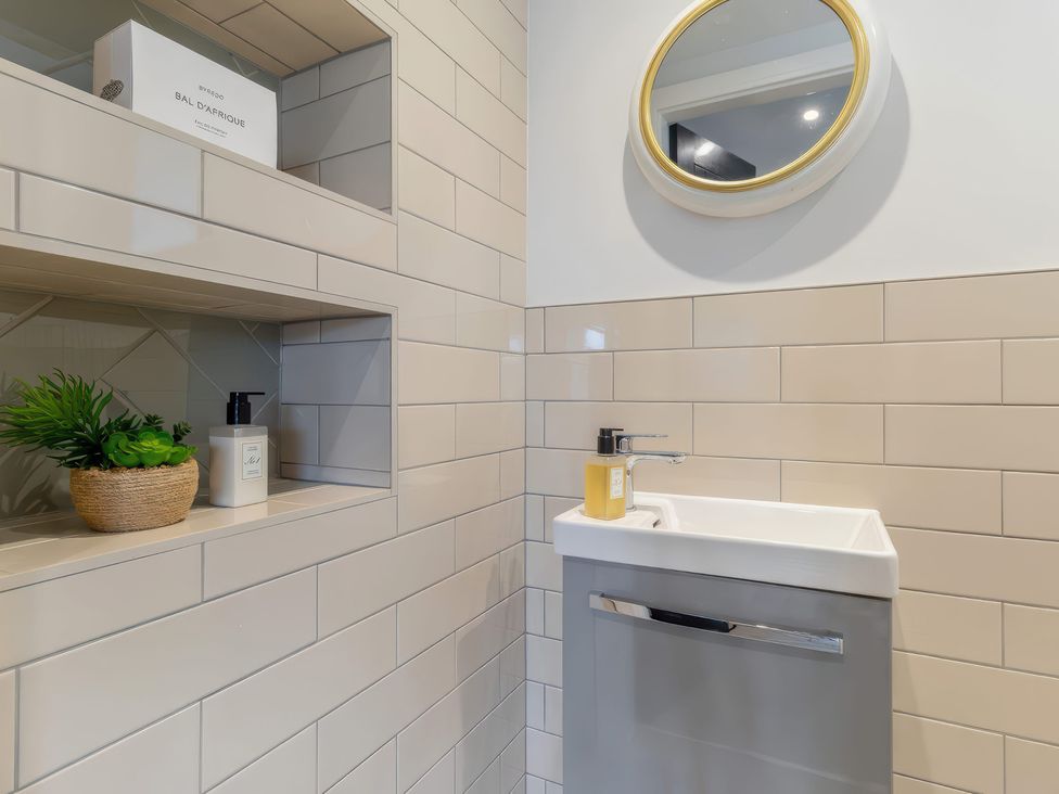 A bathroom with sink, mirror and shelves at The Old Butchers Arms in Sheffield
