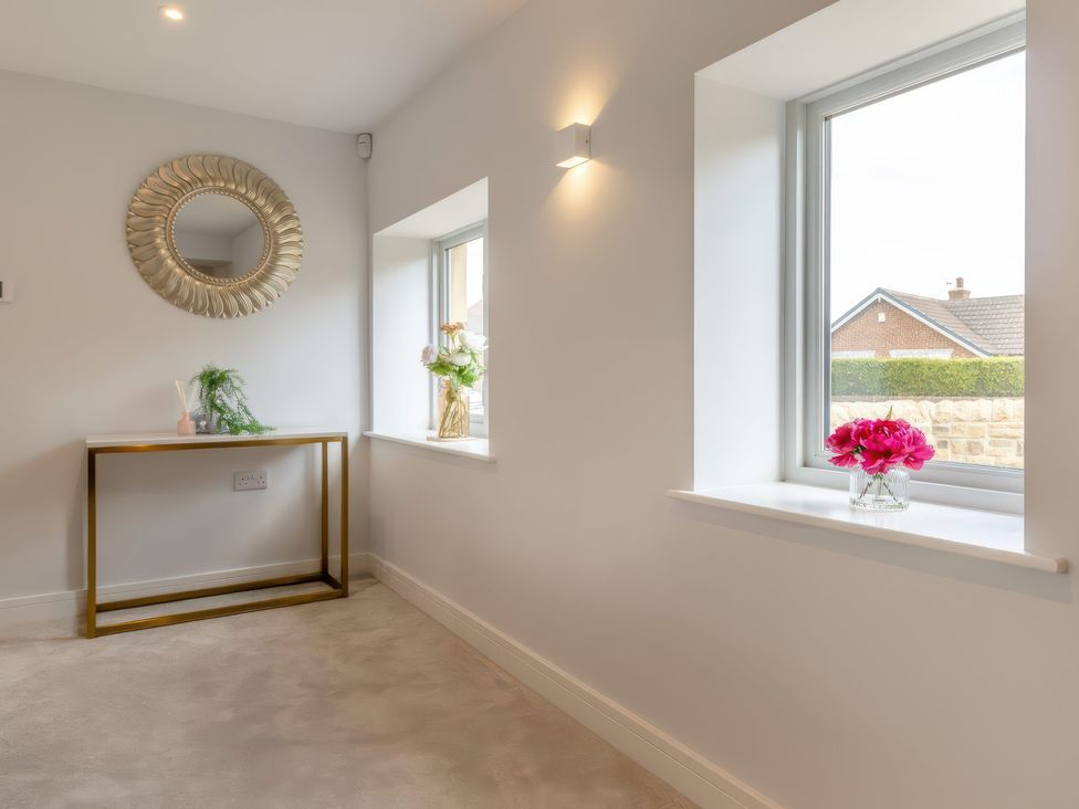 A hallway with a console table and flower vase at The Old Butchers Arms in Sheffield
