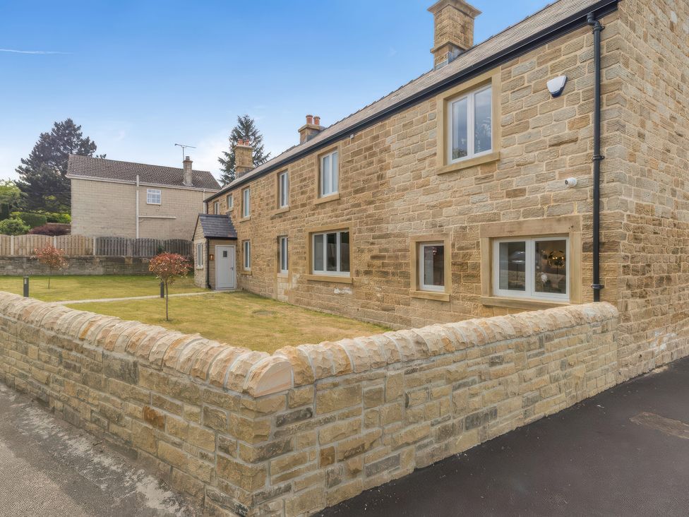 A stone house with a garden and fence at The Old Butchers Arms in Sheffield