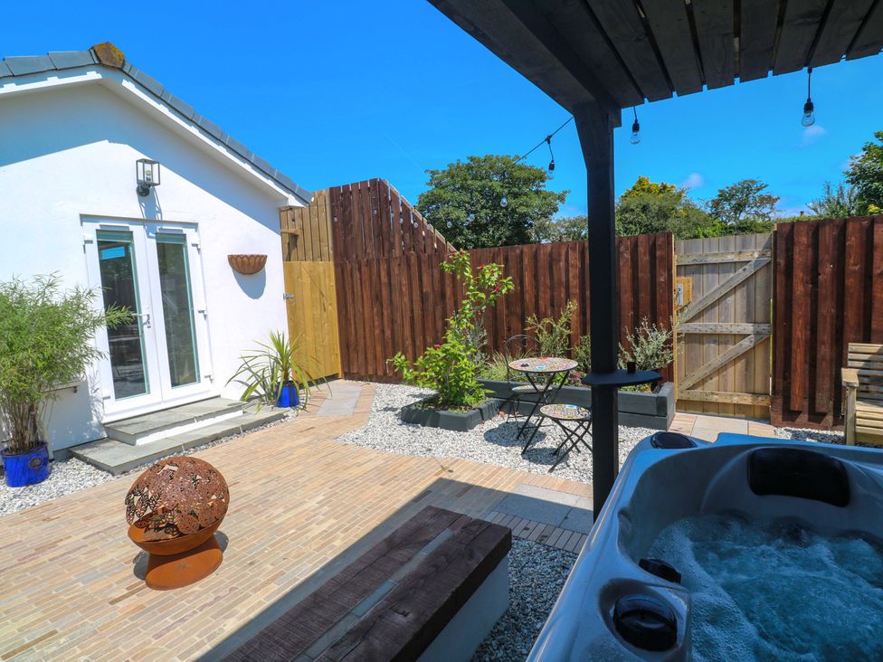 A garden with a hot tub and outdoor seating at Carn Brea in Redruth