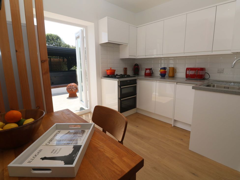 A kitchen with a table and chair at Carn Brea in Redruth