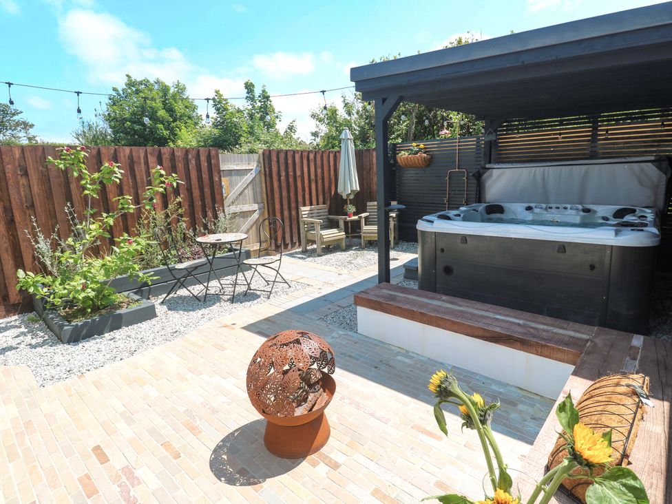 A garden with a hot tub and seating area at Carn Brea in Redruth