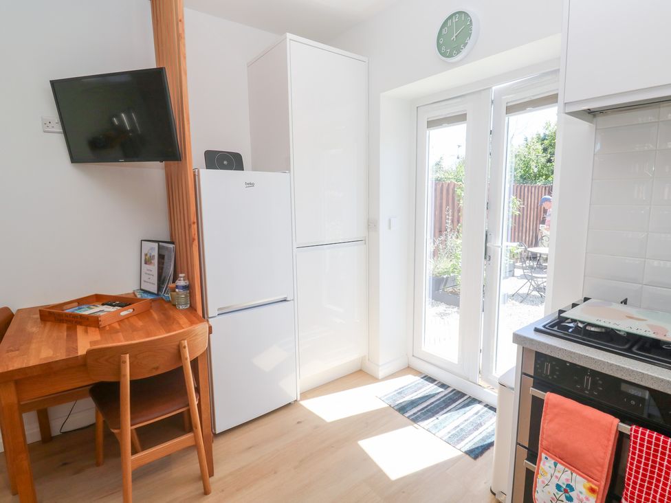 A kitchen with a table and chairs and a refrigerator at Carn Brea in Redruth