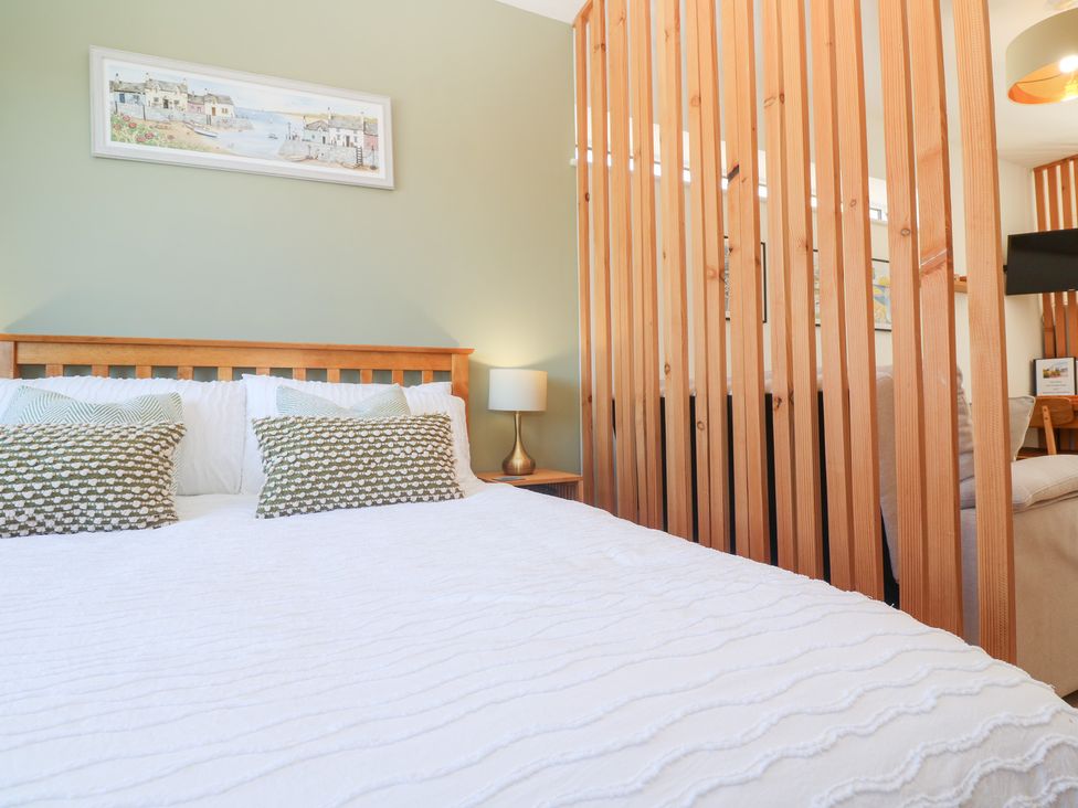 A bedroom with a bed and wooden partition at Carn Brea in Redruth