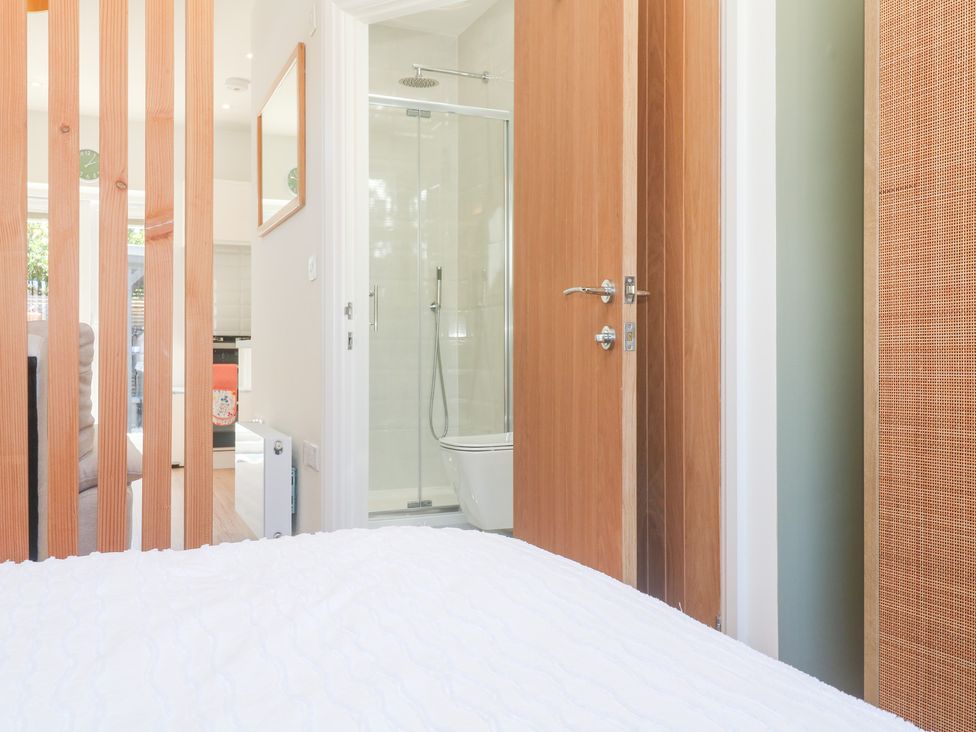 A bedroom with wooden door and shower area at Carn Brea in Redruth