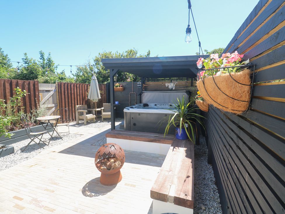 A garden with a hot tub and wooden seating at Carn Brea in Redruth