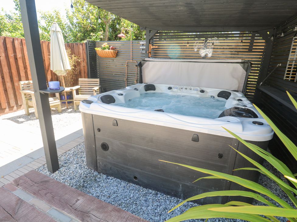 An outdoor space with a hot tub and seating area at Carn Brea, Redruth