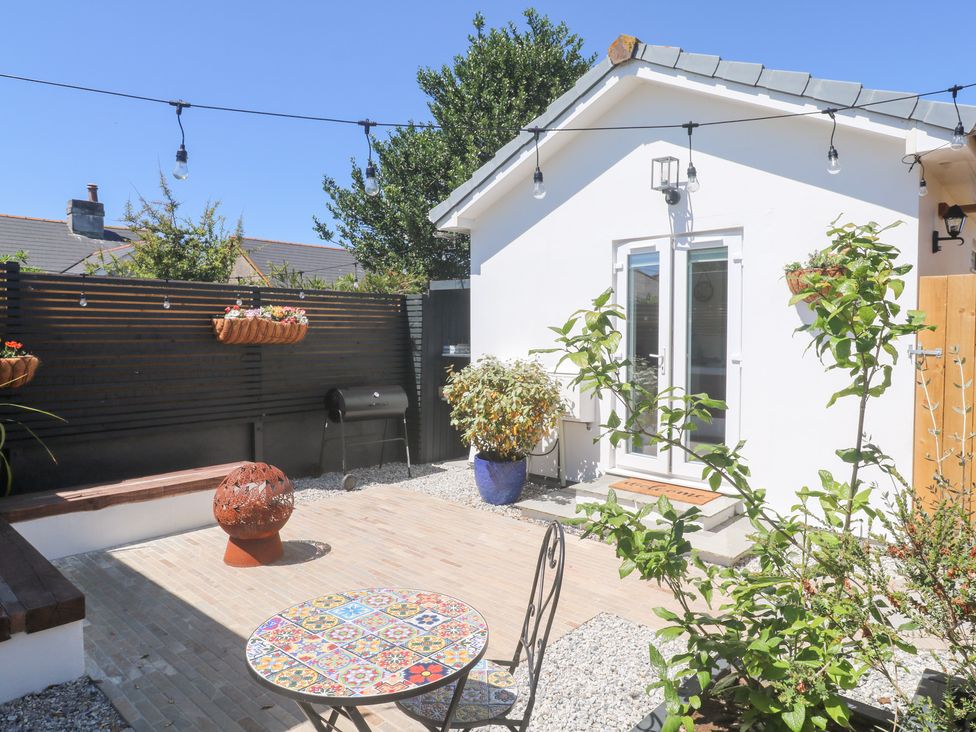 A garden with a table and chairs at Carn Brea in Redruth