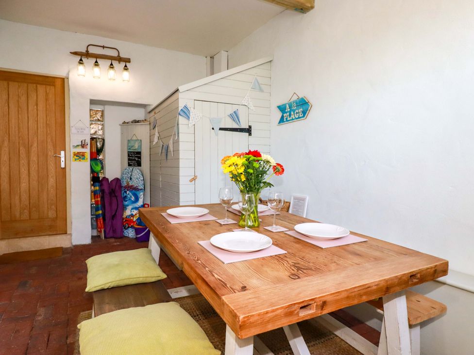 A dining room with a wooden table and flower vase at 3 The Old Cornstore 