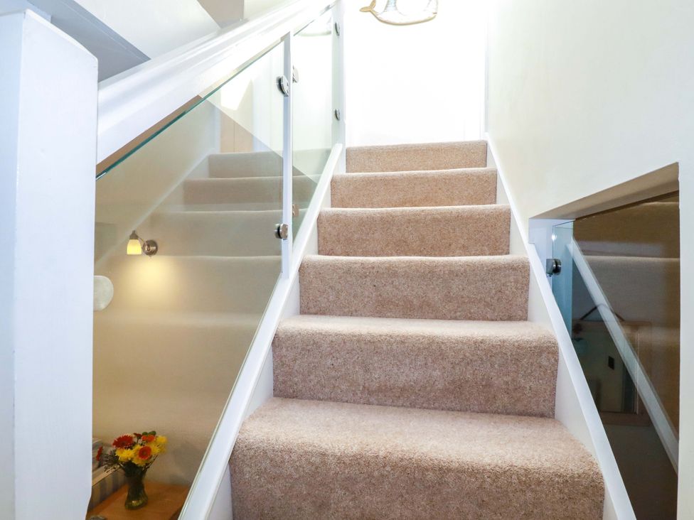 A staircase with carpet and glass railing at 3 The Old Cornstore
