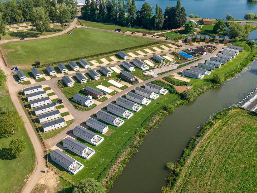 An outdoor view of a holiday park with caravans and a river at Nature's Nook - Billing Aquadrome