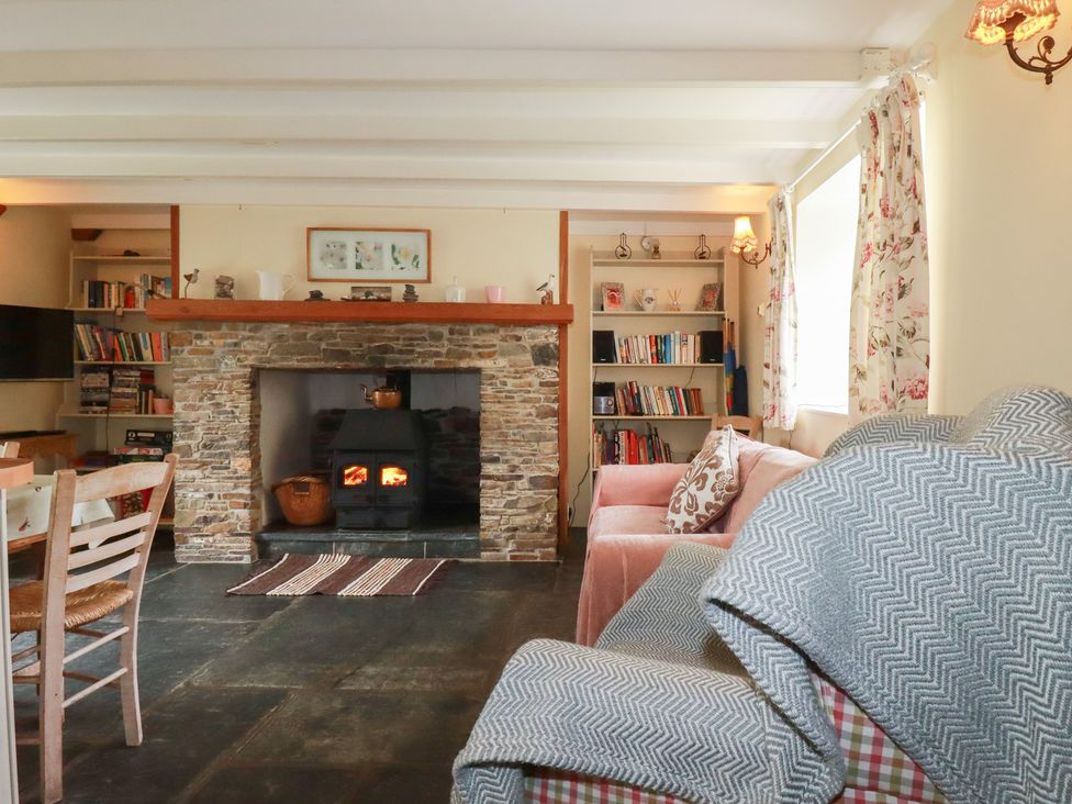 A living room with a fireplace and bookshelf at Trevean in Bude