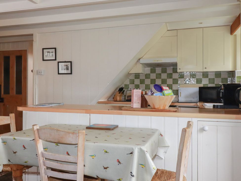 A kitchen with a table and chairs at Trevean in Bude