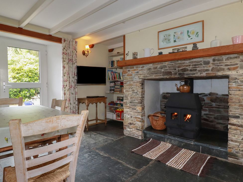 A dining room with a fireplace and a television at Trevean in Bude