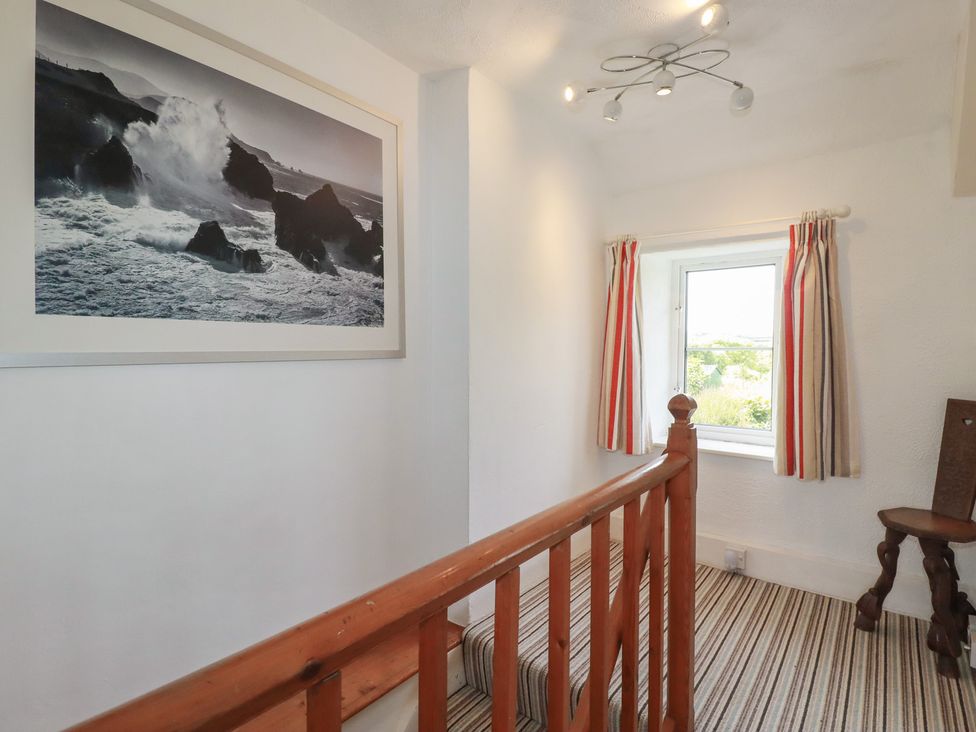 A staircase with a framed photo and a window at Trevean in Bude