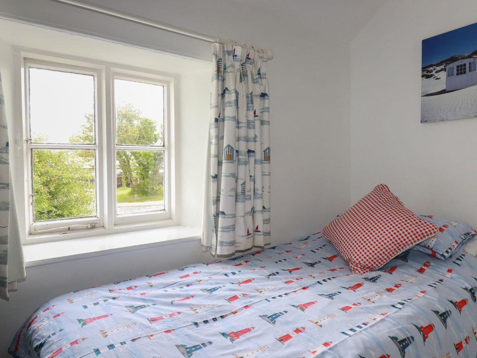 A bedroom with a bed next to a window at Trevean in Bude