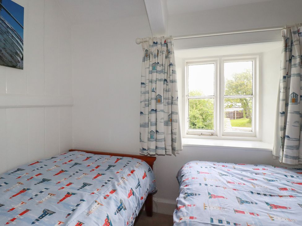 A bedroom with two beds and a window at Trevean in Bude