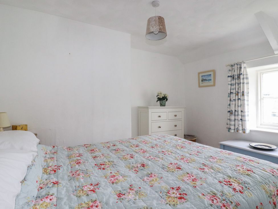 A bedroom with a bed and a dresser at Trevean in Bude