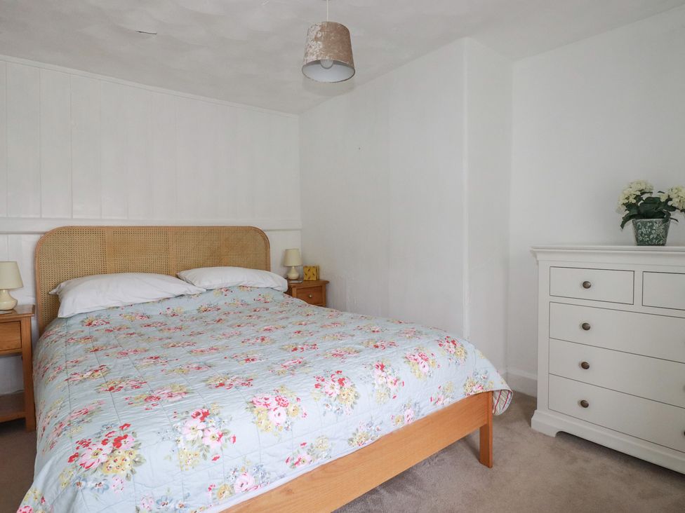 A bedroom with a bed and dresser at Trevean in Bude