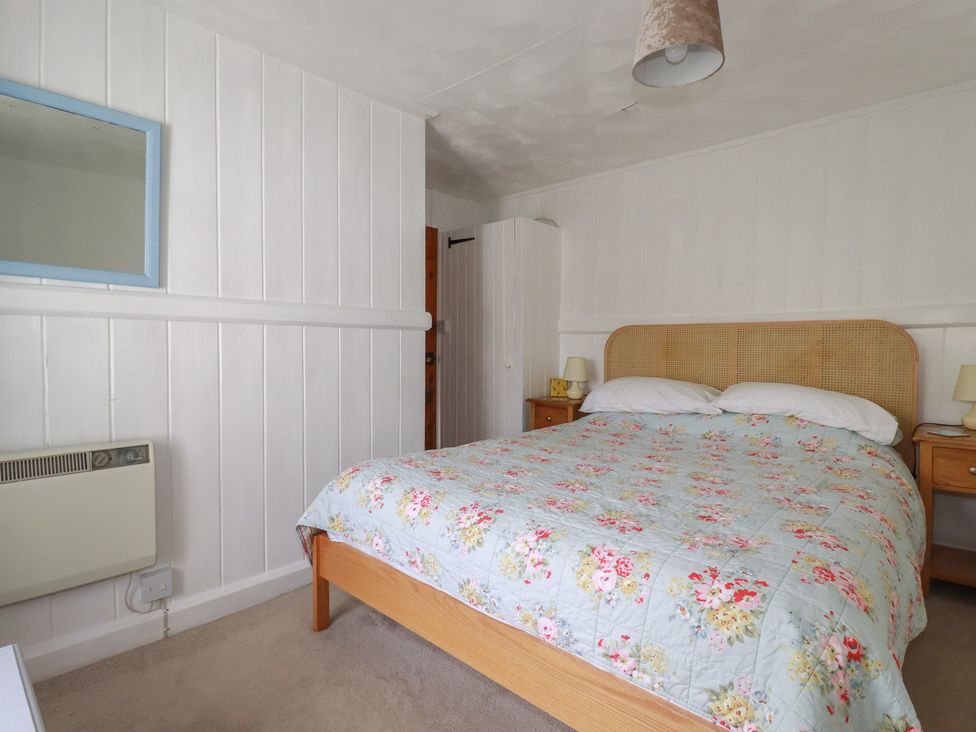 A bedroom with a bed and bedside tables at Trevean in Bude