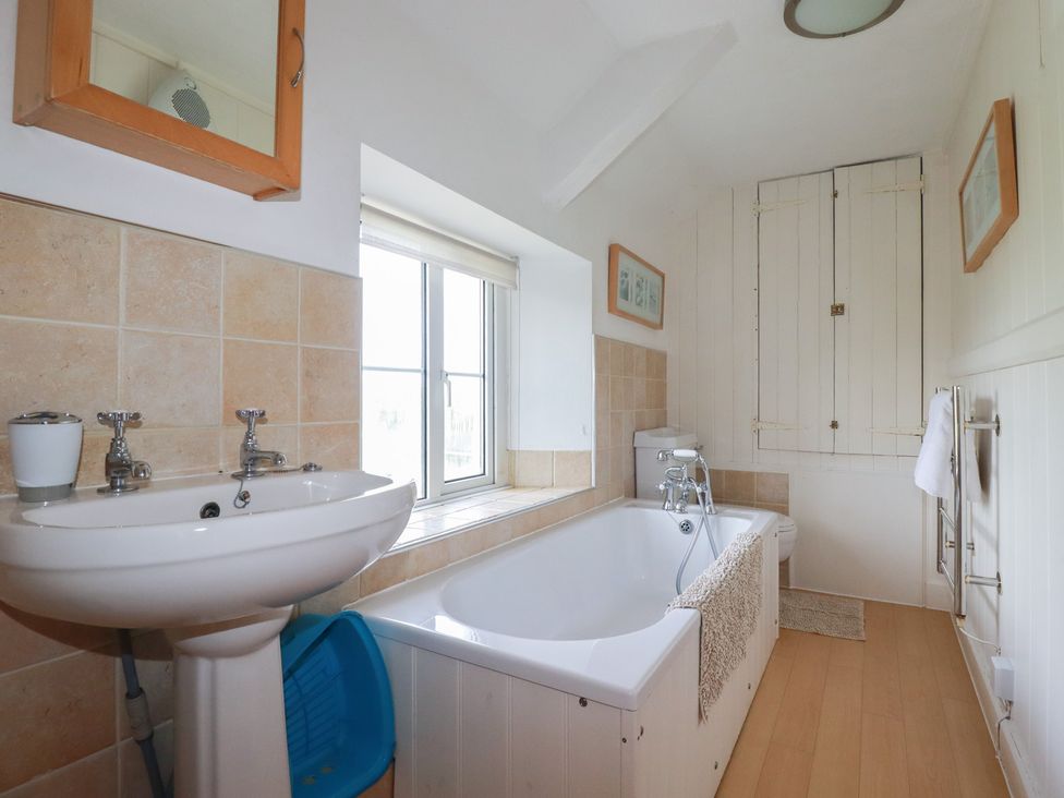 A bathroom featuring a washbasin and bathtub at Trevean in Bude