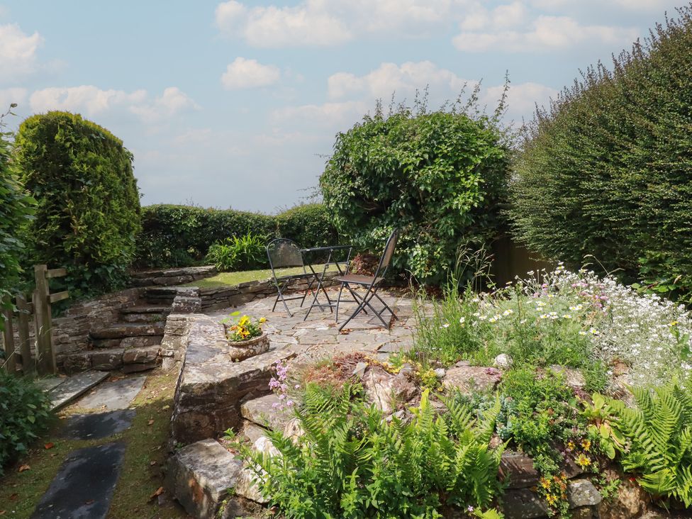 A garden with chairs and flowers at Trevean in Bude