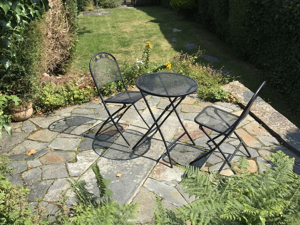 A garden area with a table and two chairs at Trevean in Crackington Haven