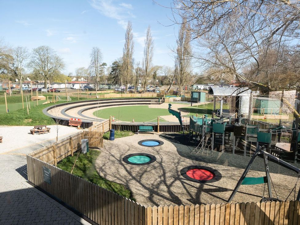 An outdoor playground with slides and benches at Skylight Stargazer - Billing Aquadrome Holiday Park