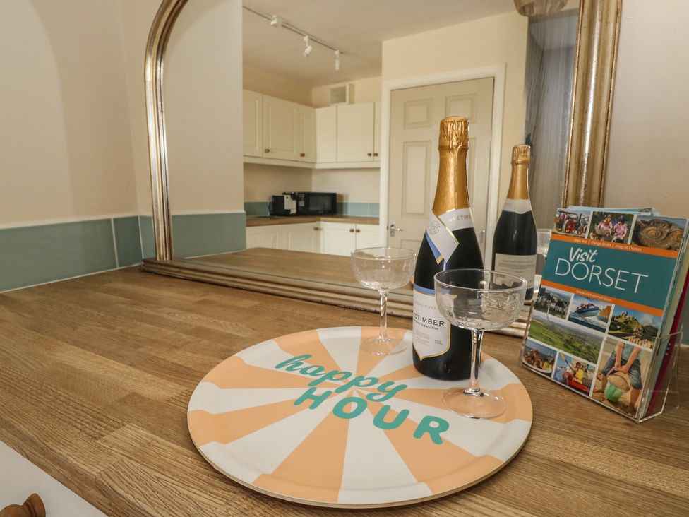 A kitchen countertop with champagne and glasses at Mallow Cottage in Langton Matravers