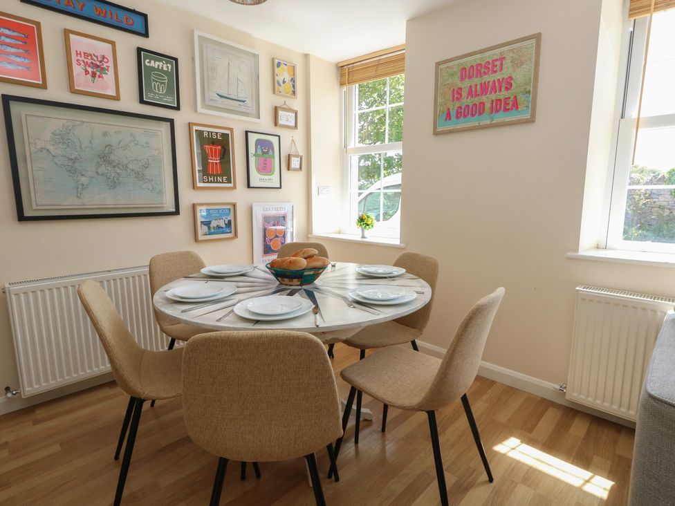 A dining room with a table and chairs at Mallow Cottage in Langton Matravers