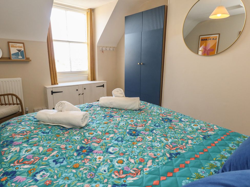 A bedroom with a bed and window at Mallow Cottage in Langton Matravers