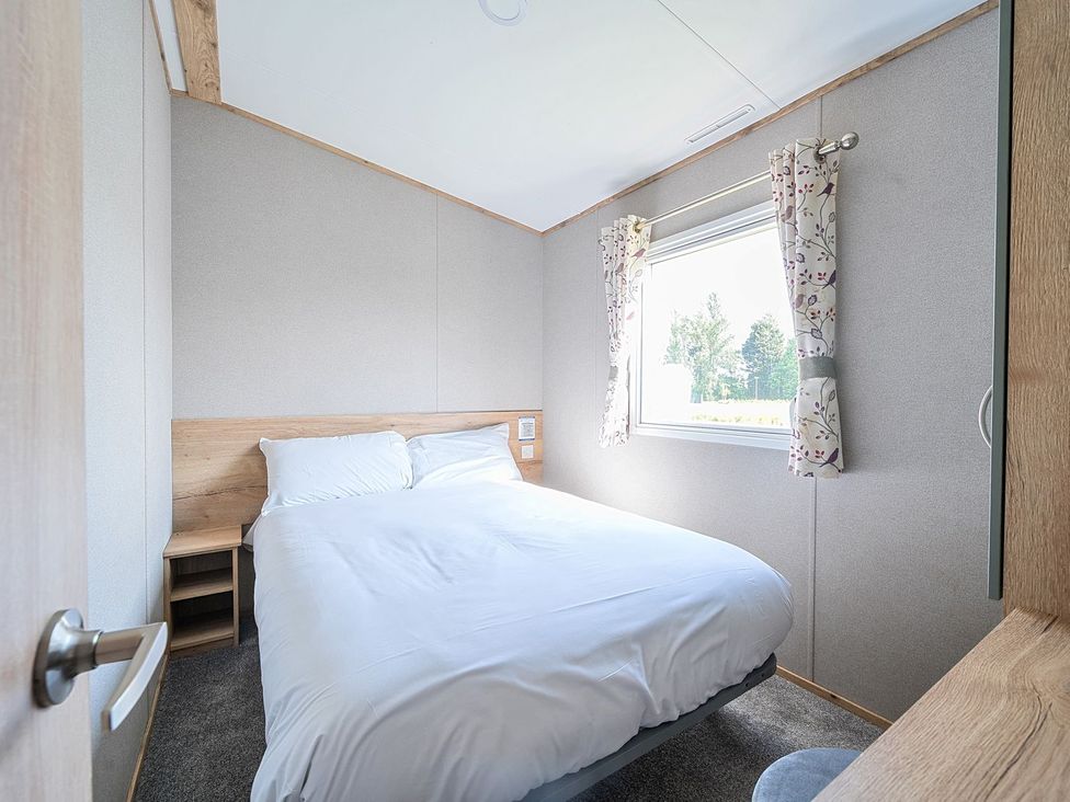 A bedroom with a bed and window at Dune Delight - Hayling Island