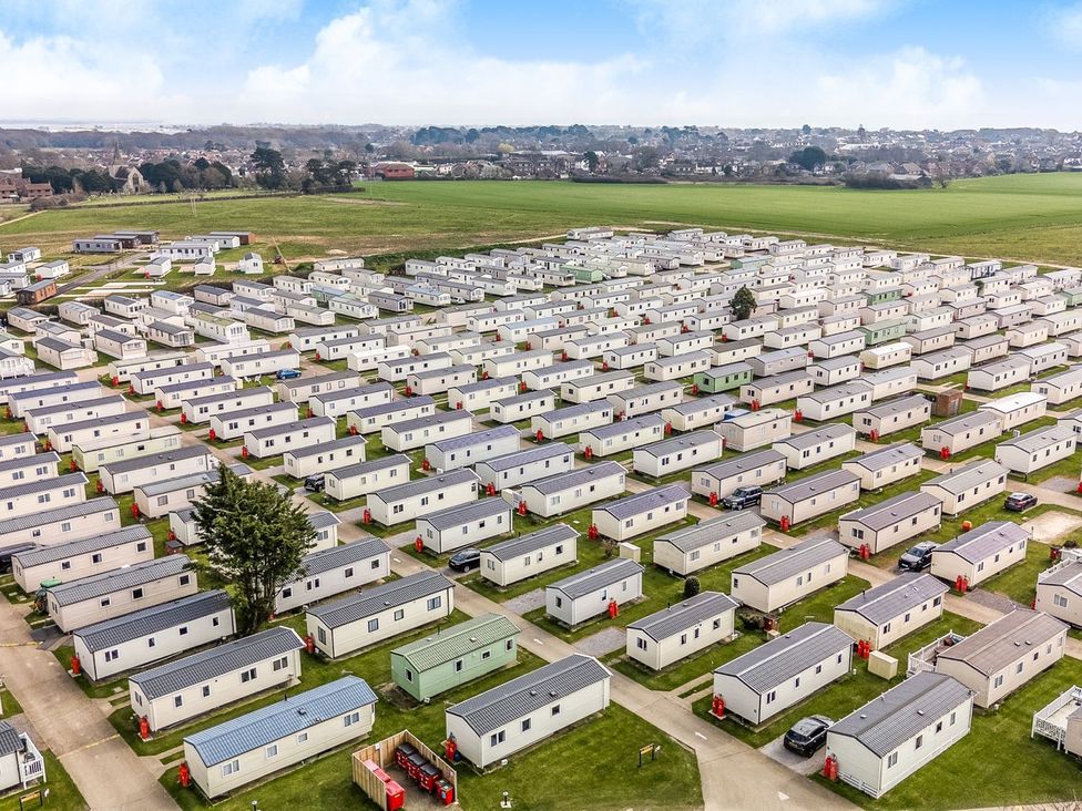 An outdoor view of mobile homes arranged in a park at Dune Delight - Hayling Island