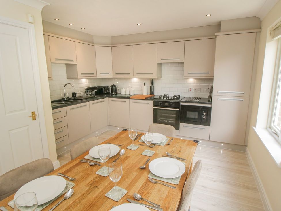 A kitchen with a dining table and appliances at The Shipwrights in Whitby