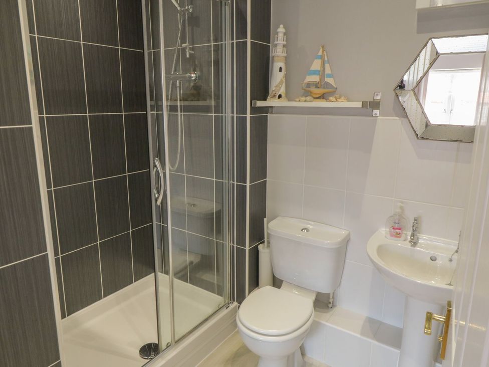 A bathroom with a shower, toilet, and sink at The Shipwrights in Whitby