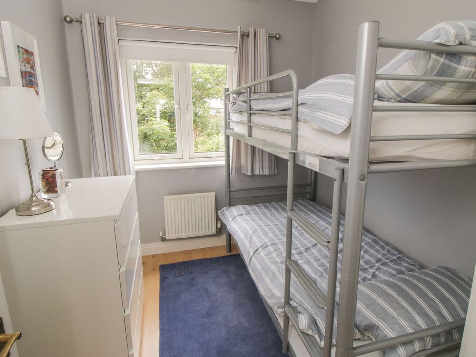A bedroom with a bunk bed and a dressing table at The Shipwrights in Whitby