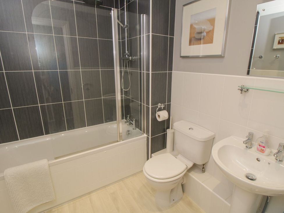 A bathroom with a bathtub, shower, toilet, and sink at The Shipwrights in Whitby