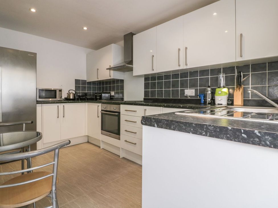 A kitchen with appliances and furniture at Chy Vean in St. Agnes