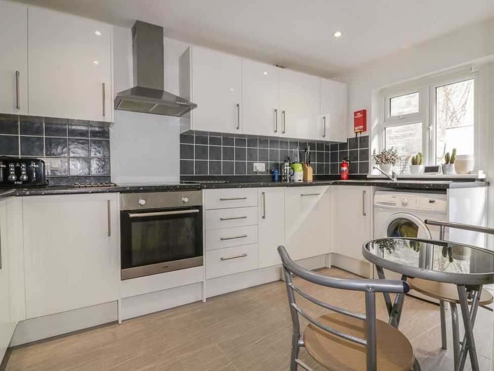 A kitchen with appliances and dining set at Chy Vean in St. Agnes